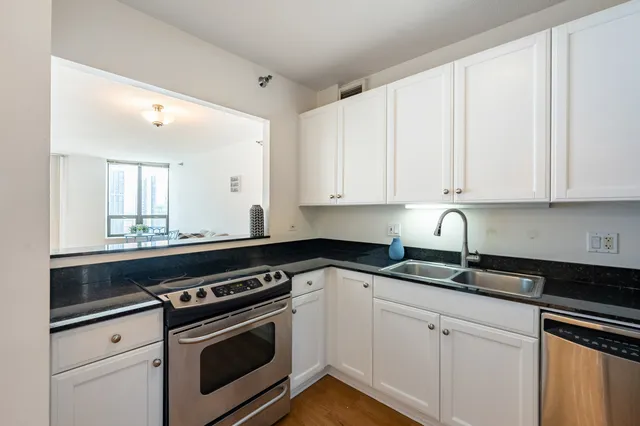 a kitchen with granite countertop white cabinets and white appliances