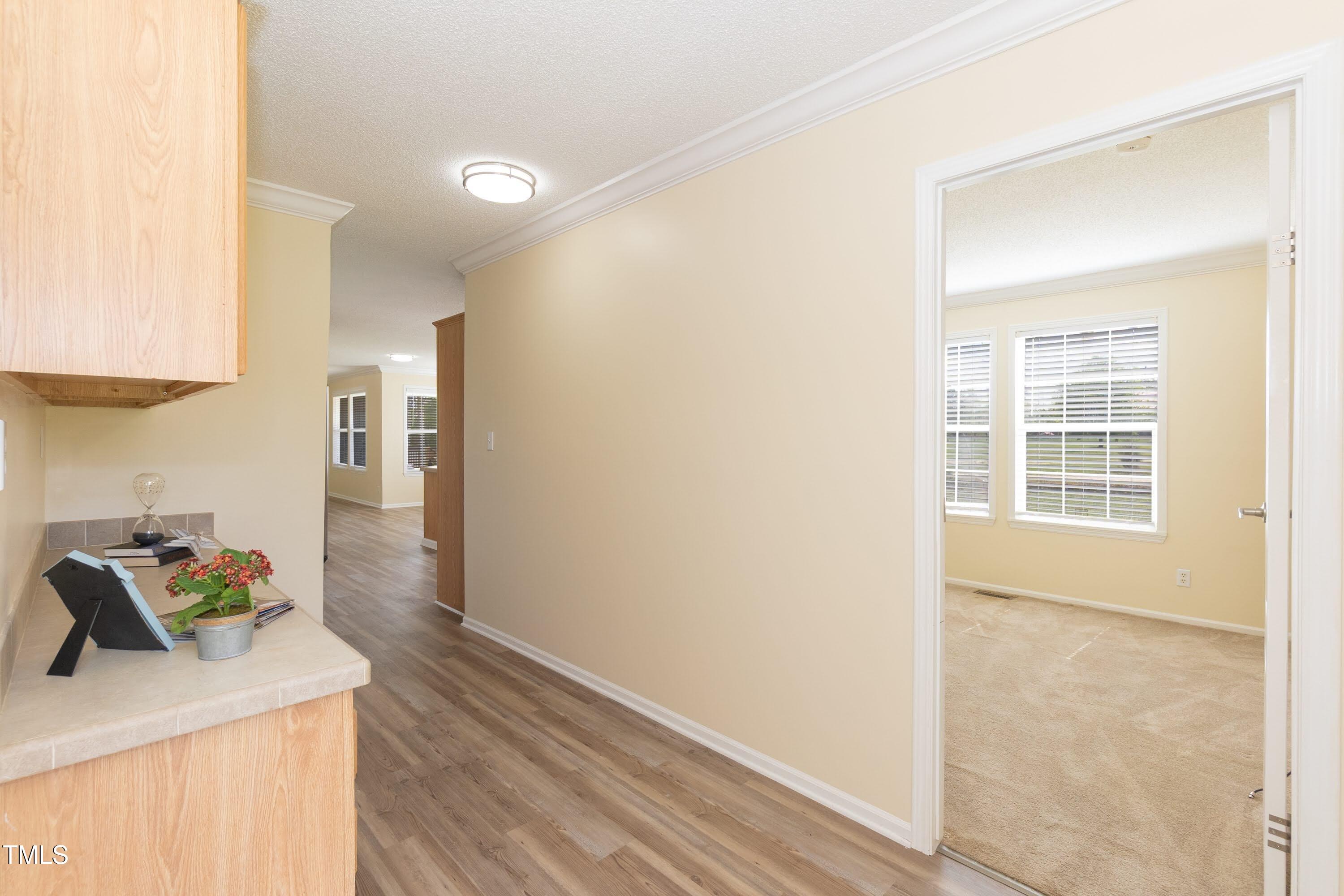 660 Our Way Linden, NC 28356 - Photo 16 of 36 a hallway with kitchen island a stove a wooden floor and a sink