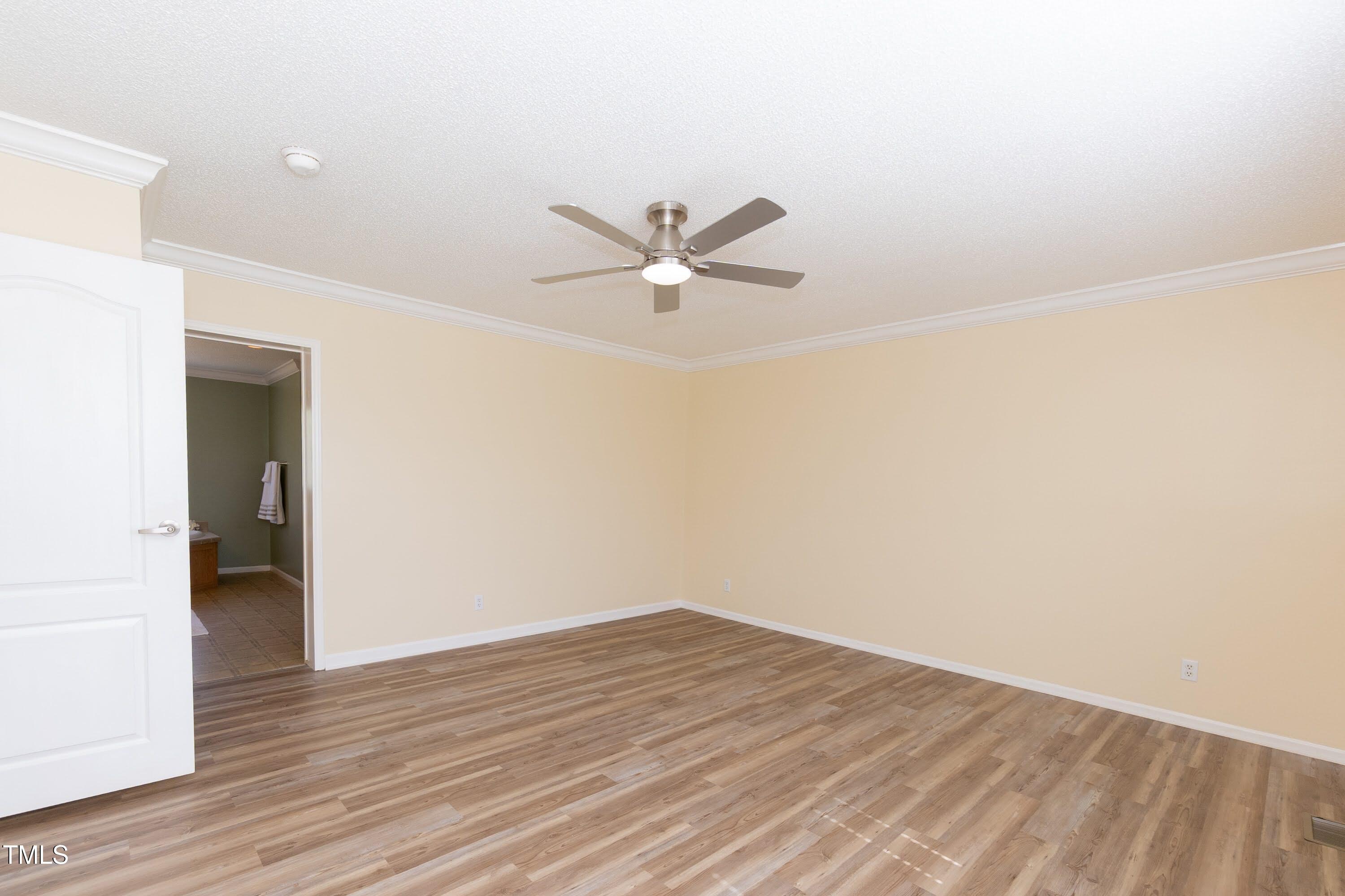 660 Our Way Linden, NC 28356 - Photo 18 of 36 an empty room with wooden floor and a ceiling fan
