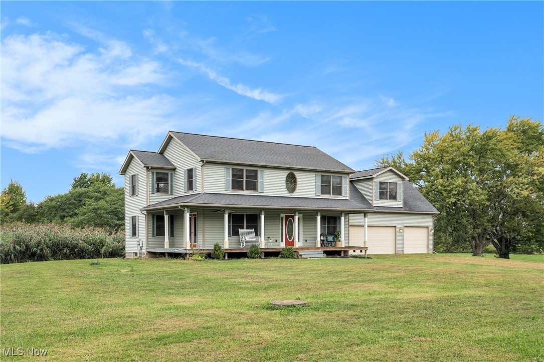 2073 Sexton Road Austinburg, OH 44010 - Photo 2 of 32 View of front of property with covered porch, a front lawn, a garage, and a shingled roof