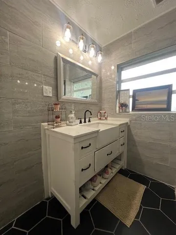 a bathroom with a sink mirror and a toilet