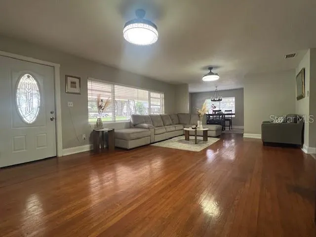 a living room with furniture and a wooden floor