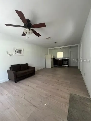 a living room with furniture and a ceiling fan