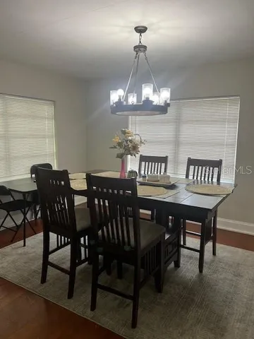 a view of a dining room with furniture a chandelier and wooden floor