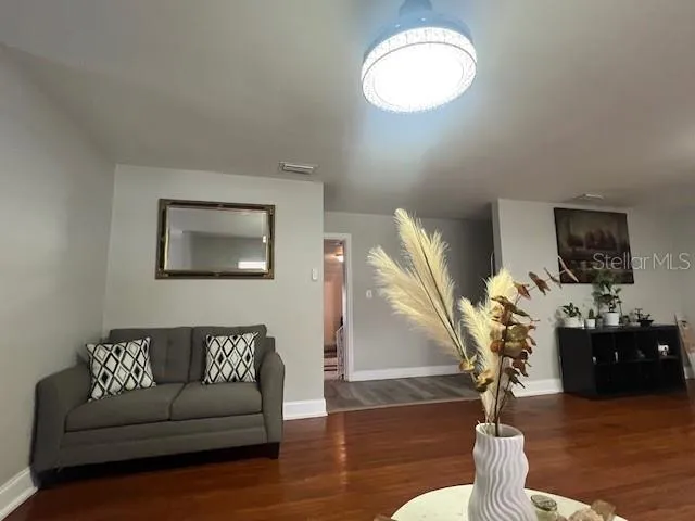 a living room with furniture and wooden floor