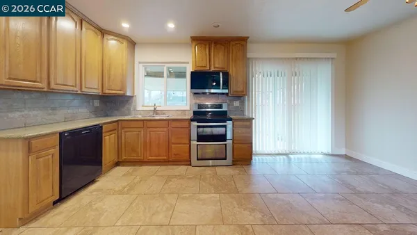 a large kitchen with stainless steel appliances granite countertop a stove granite counter tops and white cabinets