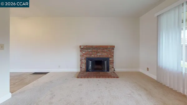 a view of an empty room with a fireplace