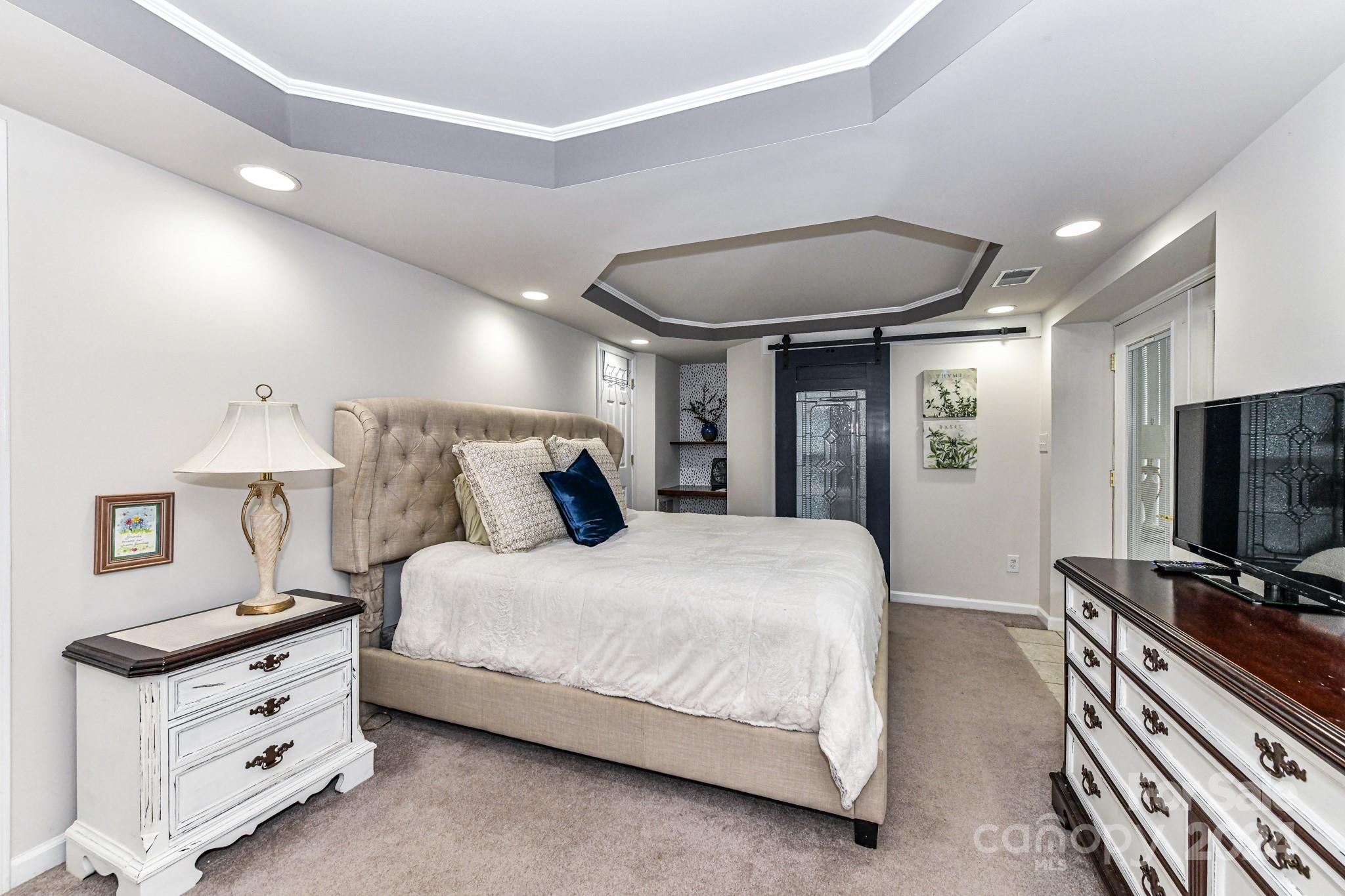 334 Ervin Road Mooresville, NC 28117 - Photo 29 of 48 a spacious bedroom with a bed and a flat screen tv