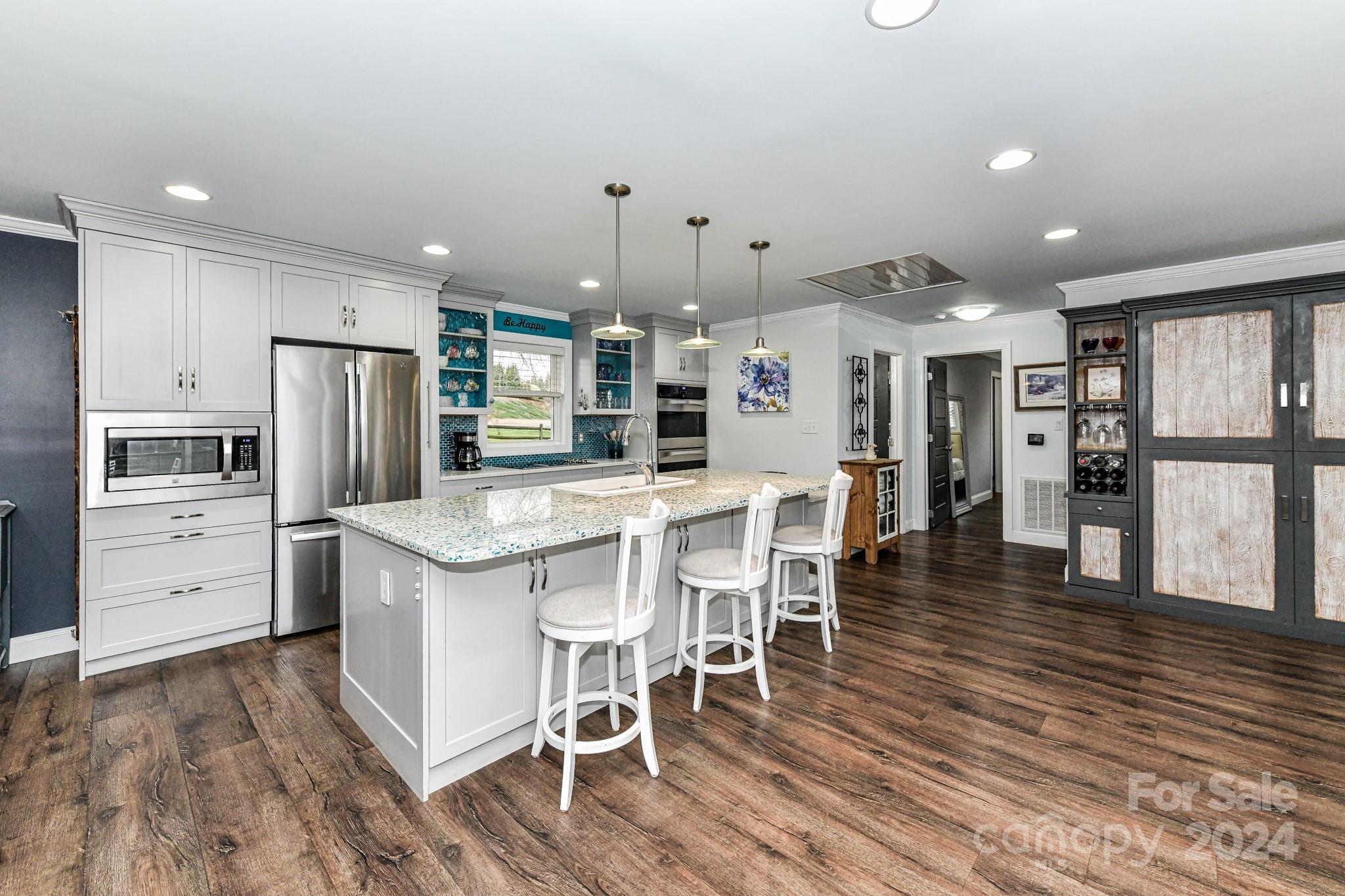 334 Ervin Road Mooresville, NC 28117 - Photo 9 of 48 a kitchen with stainless steel appliances kitchen island granite countertop a refrigerator and wooden floor