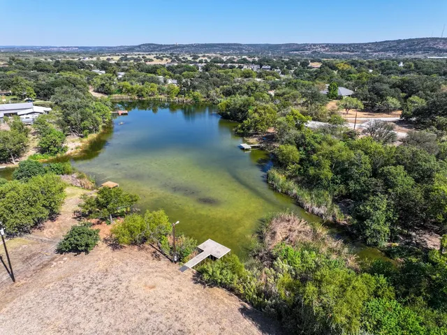 an aerial view of residential houses with outdoor space and lake view