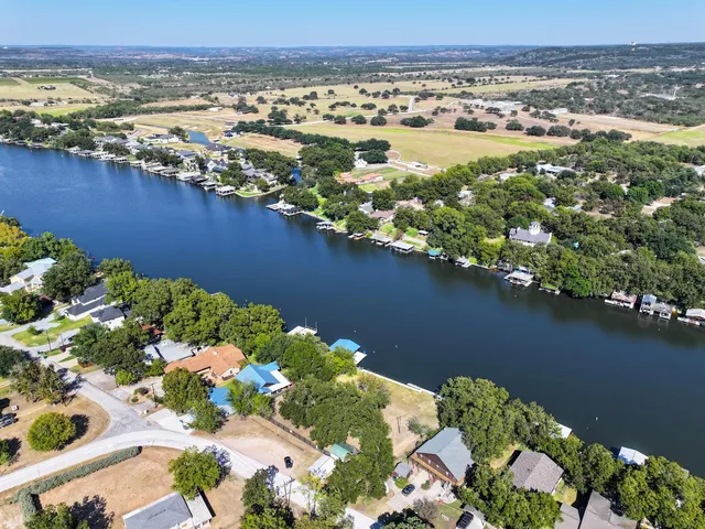 an aerial view of residential houses with outdoor space and trees