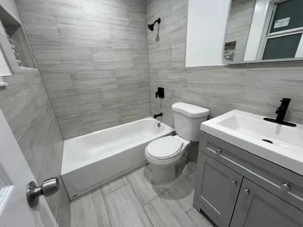 a bathroom with a white toilet sitting next to a bathtub