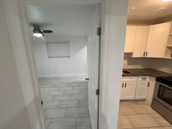 a kitchen with white cabinets and white appliances
