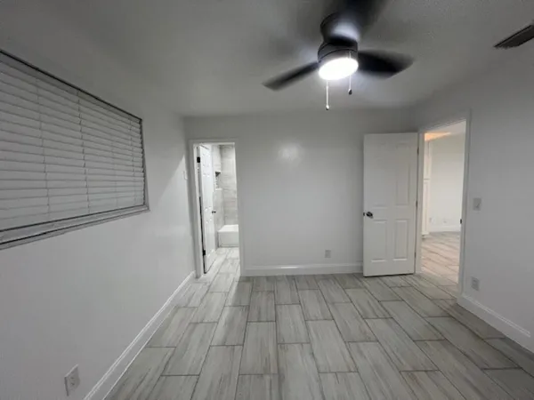 a view of empty room with wooden floor