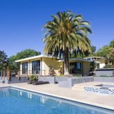 a front view of a house with swimming pool and porch