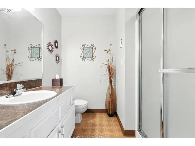 a bathroom with a granite countertop sink a toilet and a mirror