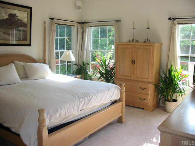 9016 Breeland Way Raleigh, NC 27613 - Photo 6 of 10 a bedroom with a bed potted plant and a window