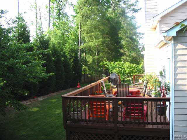 9016 Breeland Way Raleigh, NC 27613 - Photo 9 of 10 a view of a wooden deck with large trees and wooden fence