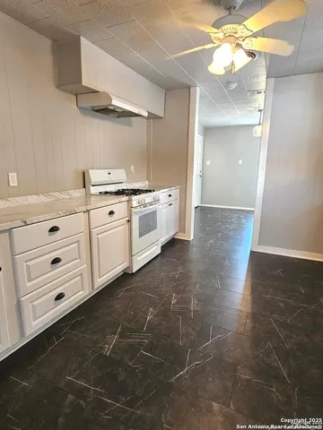a large white kitchen with cabinets and a stove