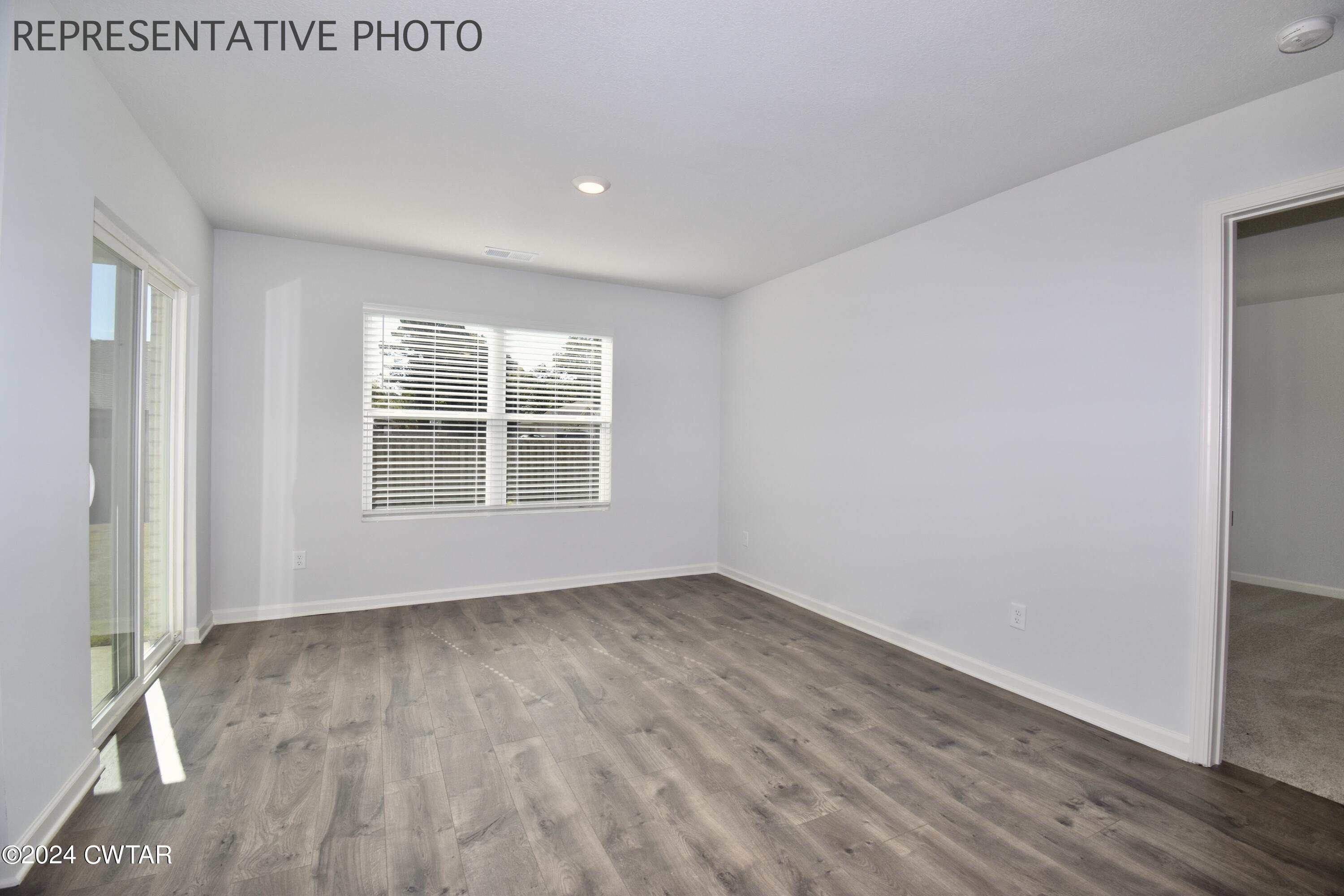 61 Vintage Grove Road Jackson, TN 38305 - Photo 12 of 25 an empty room with wooden floor and windows