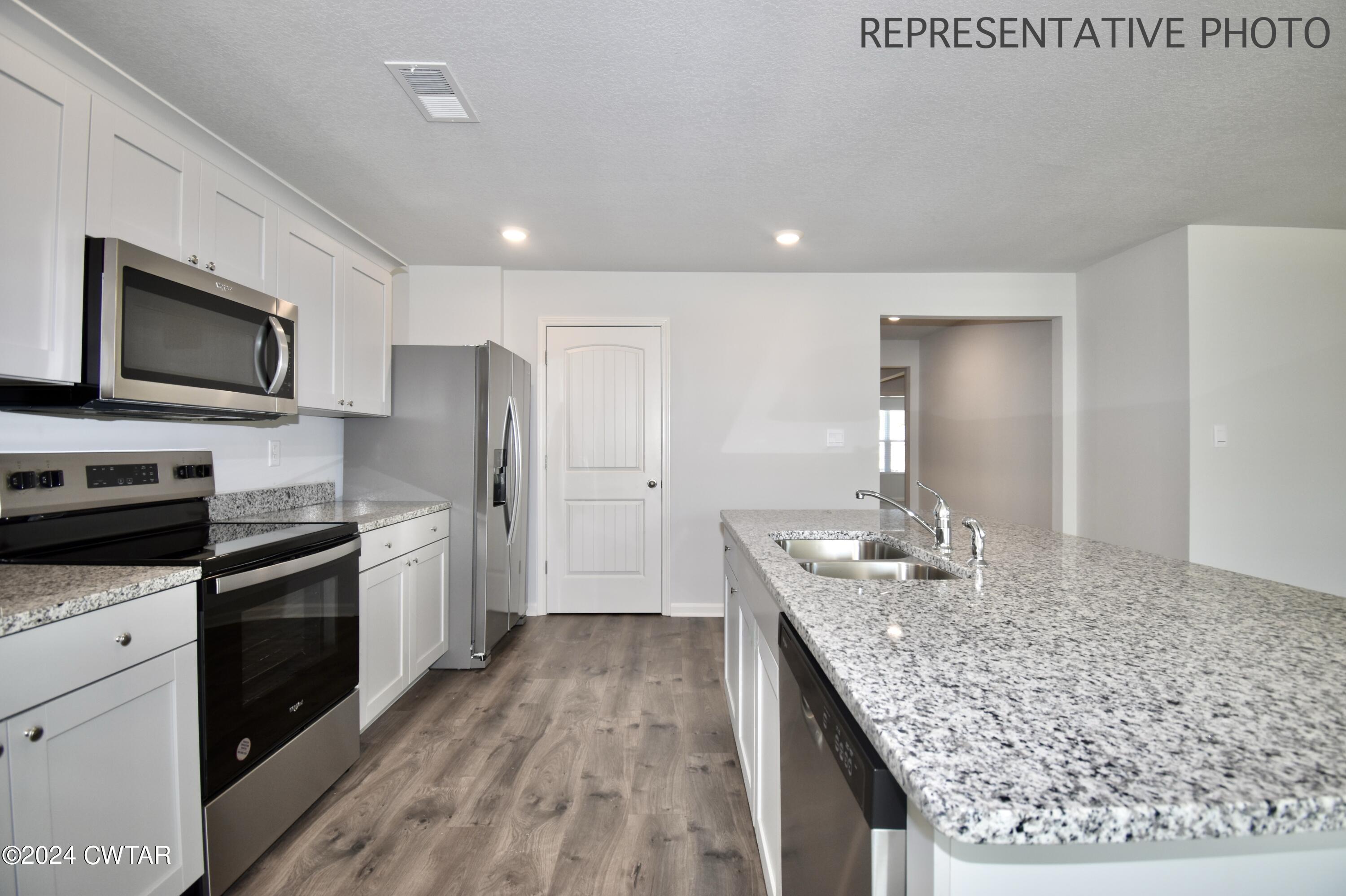 61 Vintage Grove Road Jackson, TN 38305 - Photo 14 of 25 a kitchen with stainless steel appliances granite countertop a sink stove and refrigerator