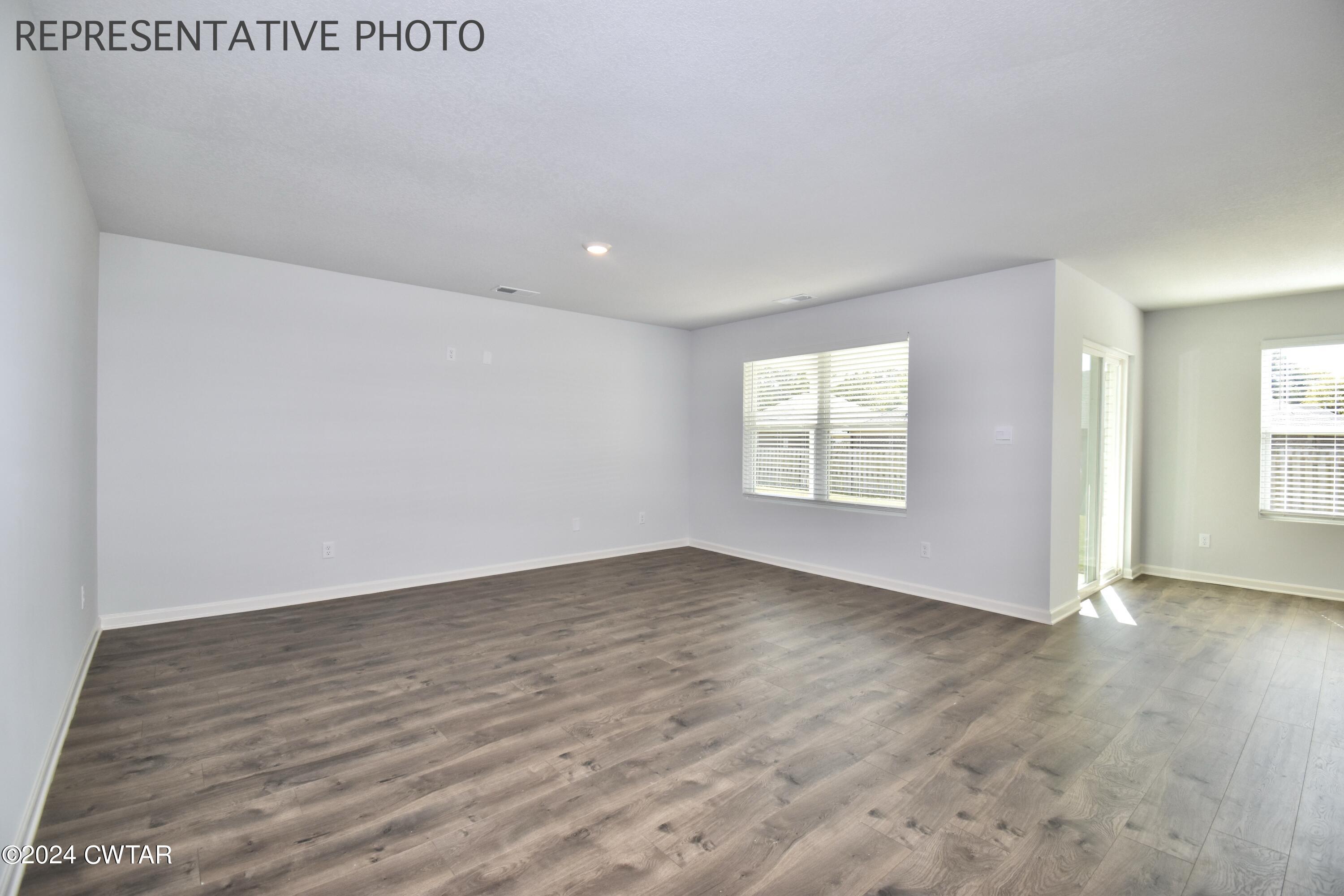 61 Vintage Grove Road Jackson, TN 38305 - Photo 3 of 25 an empty room with wooden floor and windows