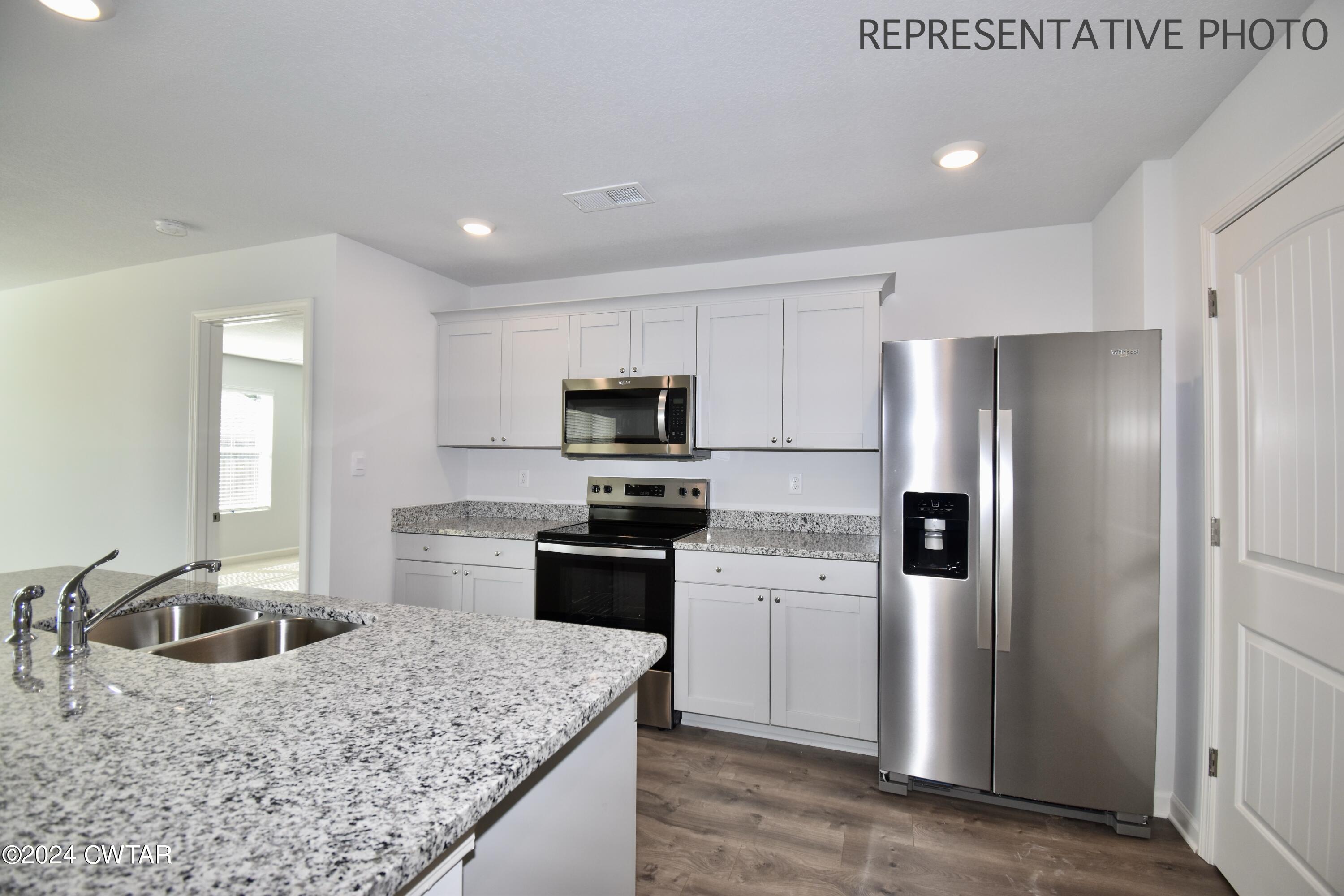 61 Vintage Grove Road Jackson, TN 38305 - Photo 8 of 25 a kitchen with stainless steel appliances granite countertop a sink stove and refrigerator