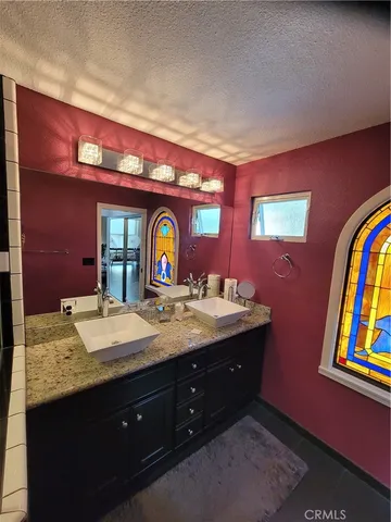 a bathroom with a granite countertop sink and a mirror