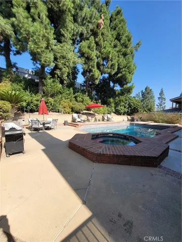 a view of a swimming pool with an outdoor seating and a forest