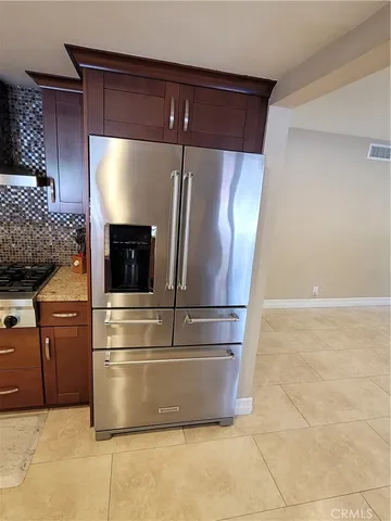 a metallic refrigerator freezer sitting in a kitchen