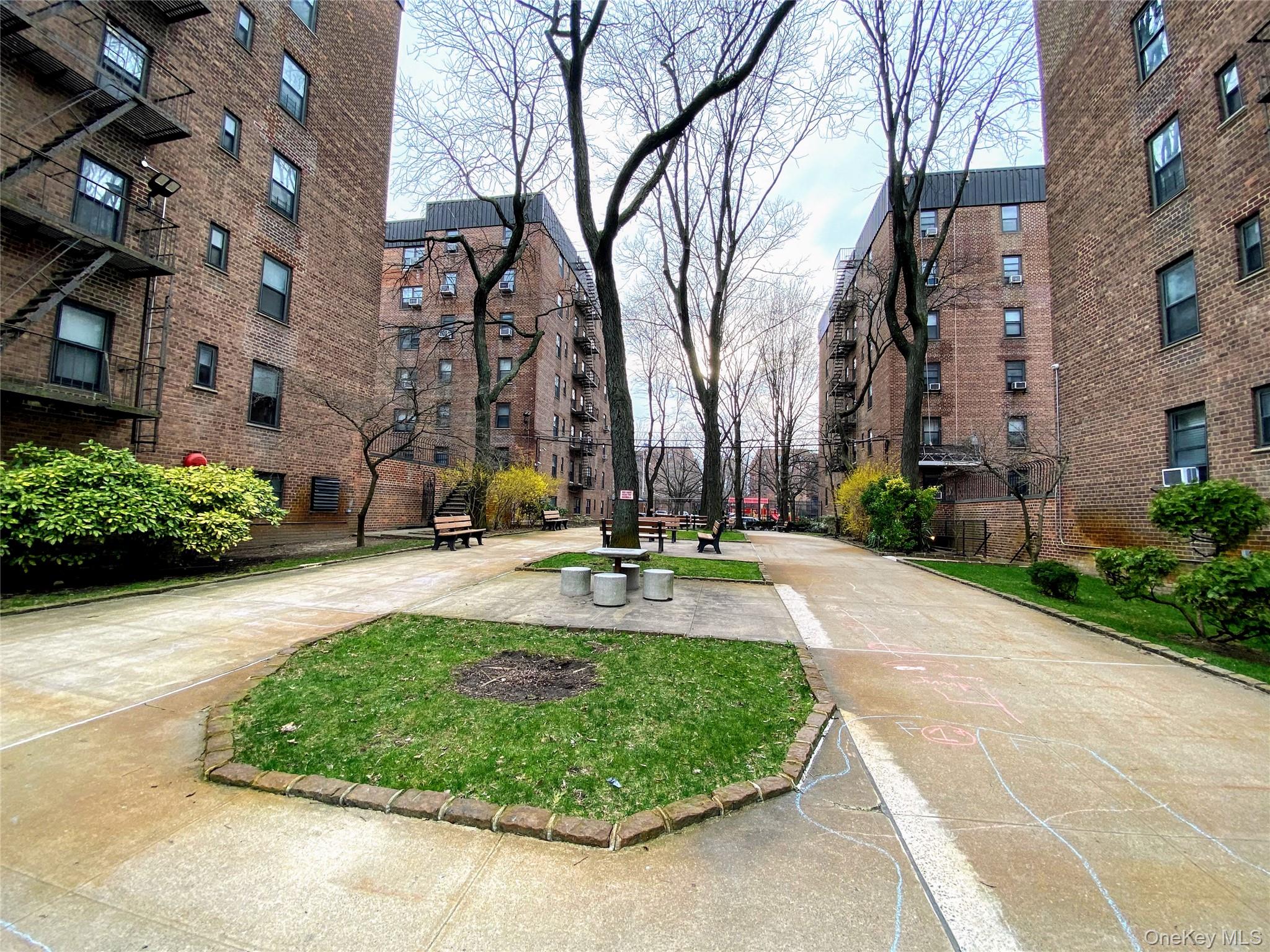 32-23 90th Street, Unit 405 Queens, NY 11369 - Photo 3 of 5 a view of a fountain in front of a brick building