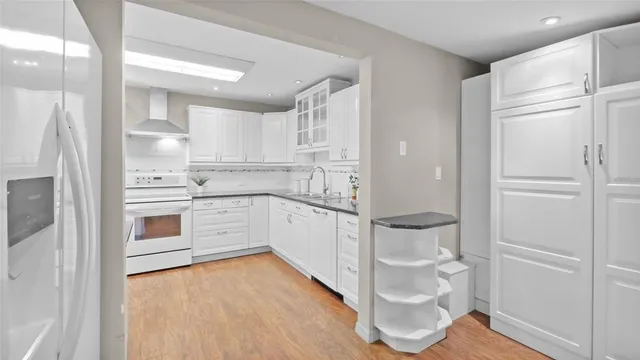 a kitchen with a refrigerator and white cabinets