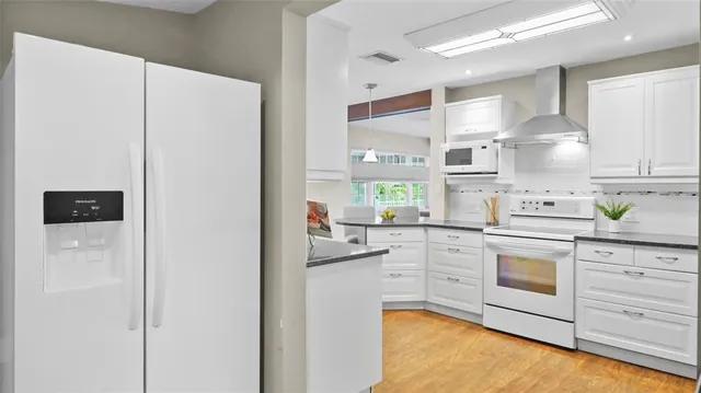 a kitchen with white cabinets and white appliances