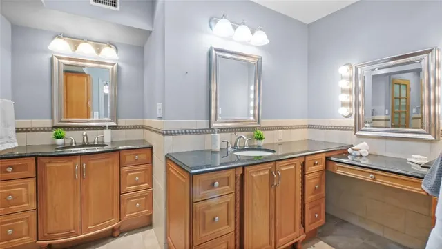 a bathroom with a granite countertop sink and a mirror