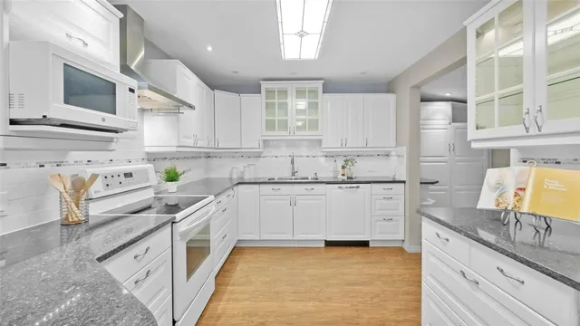 a kitchen with stainless steel appliances granite countertop a sink stove and cabinets