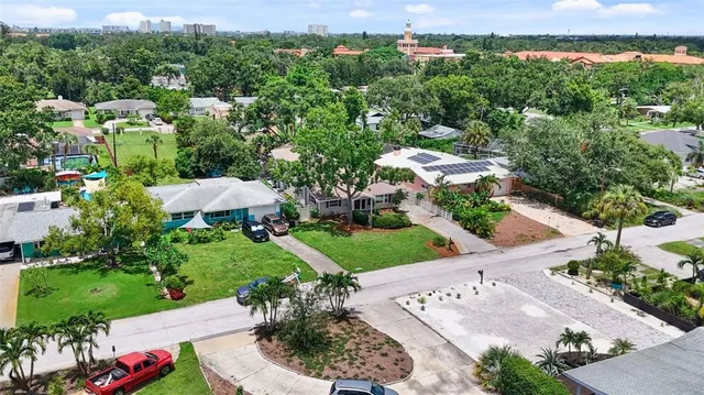 an aerial view of residential houses with outdoor space and trees