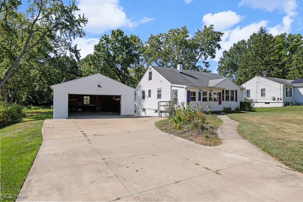1702 Far View Road Akron, OH 44312 - Photo 35 of 49 View of front of house with a front yard, a garage, an outdoor structure, and view of wooded area