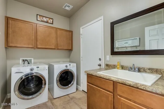 a utility room with sink dryer and washer