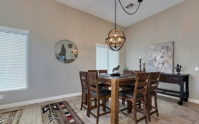 a view of a dining room with furniture a chandelier and a window