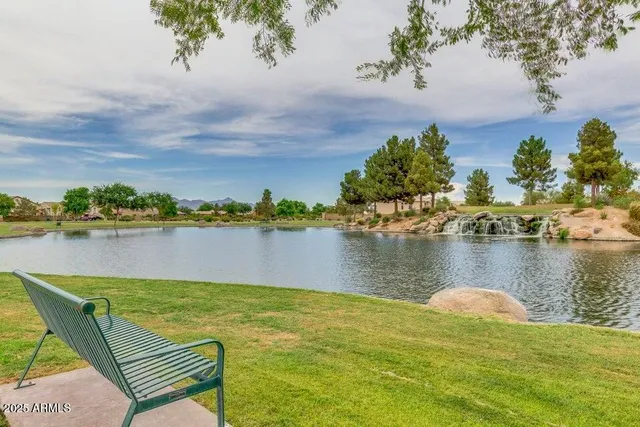 a swimming pool with lots of green space and trees in the background