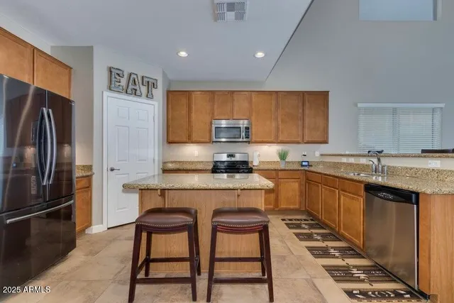 a kitchen with granite countertop a sink stainless steel appliances and cabinets