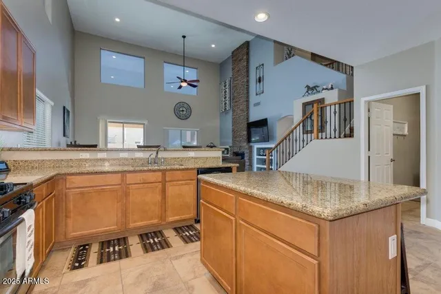 a kitchen with stainless steel appliances granite countertop a sink and a refrigerator