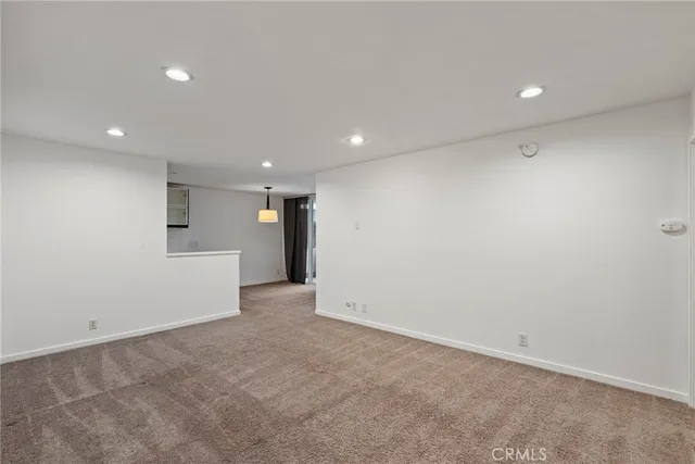 an empty room with a cabinet and mirrors