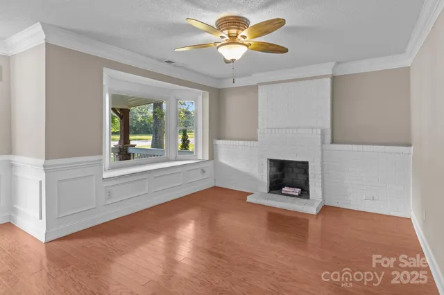 an empty room with windows and fireplace