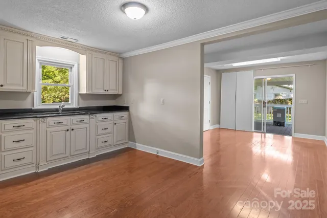 a view of a kitchen with wooden floor and cabinets
