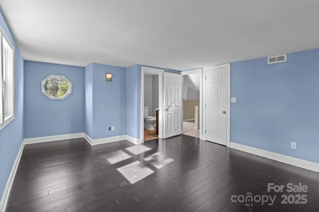 an empty room with wooden floor and window