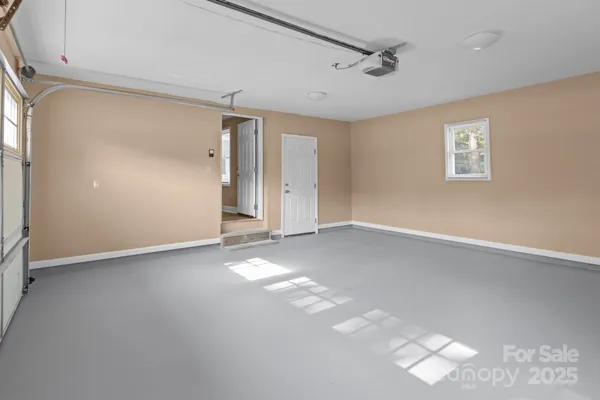 an empty room with windows and ceiling fan