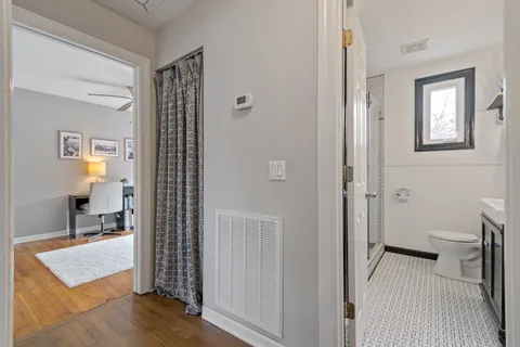 a view of a room with wooden floor and a bathroom
