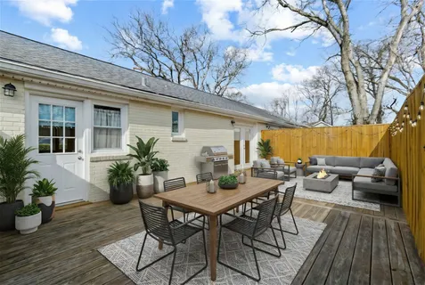 a view of a patio with couches and table and chairs with wooden floor and plants