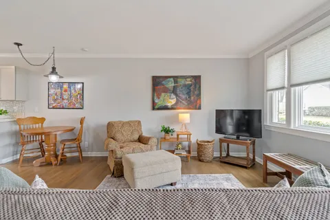 a living room with furniture a flat screen tv and a table